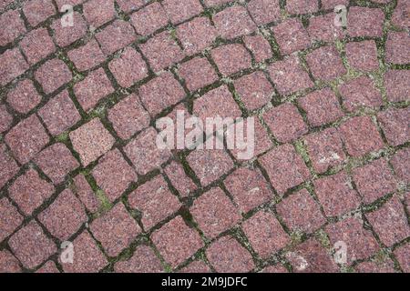 Paving stone background. Cobblestone Street. Red granite cobblestoned pavement. Natural background. Stock Photo
