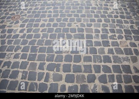 Paving stone background. Cobblestone Street. Grey granite cobblestoned pavement. Natural background. Stock Photo