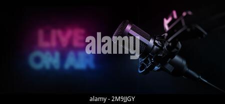 live on air. radio podcast broadcasting studio microphone with neon lights sign. banner with copy space Stock Photo