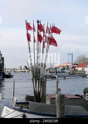 Red fishing buoy flags on bamboo poles in a Danish harbour Stock Photo -  Alamy