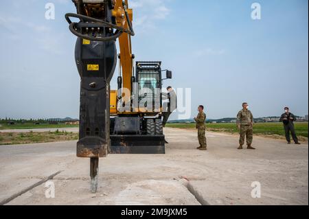 Lt. Gen. Scott Pleus, Seventh Air Force commander, climbs on an excavator with a jackhammer attachment May 19, 2022, at Osan Air Base, Republic of Korea. The equipment is used during the Rapid Airfield Damage Repair process, which the 51st CES demonstrated to Pleus during his battlefield circulation. Pleus’ battlefield circulations provide the opportunity for the 7AF commander to with airmen assigned to Osan and learn their respective missions. Stock Photo
