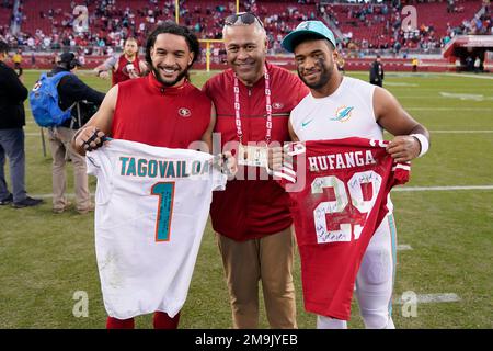 San Francisco 49ers safety Talanoa Hufanga, left, poses for photos with  former 49ers player Jesse Sapolu, middle, while exchanging jerseys with  Miami Dolphins quarterback Tua Tagovailoa, right, after an NFL football game