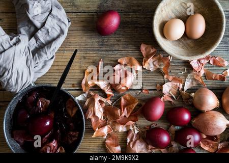 Dyed Easter eggs painted with natural dye onion on rustic wooden background. Process of dyeing eggs with natural paints for Easter. Natural ecological Stock Photo