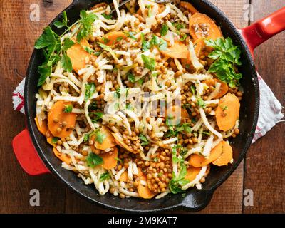 Carrots and Lentils with German Pasta (Spaetzle) in a cast iron pan. Stock Photo
