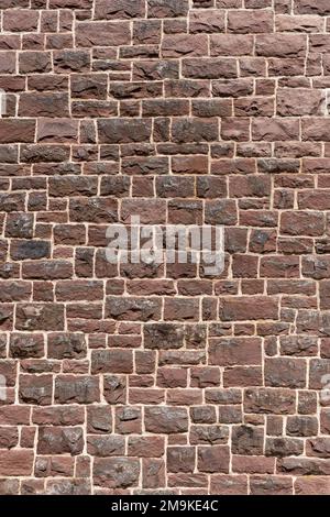Old wall made of many red sandstones in close-up portrait format Stock Photo