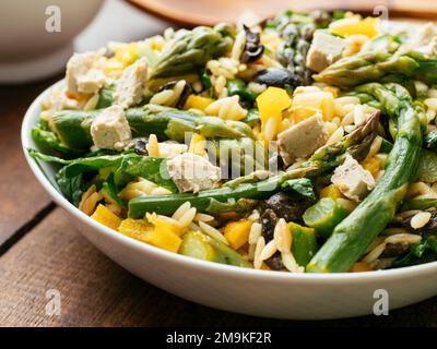 Home made asparagus, spinach orzo salad with vegan feta Cheese Stock Photo