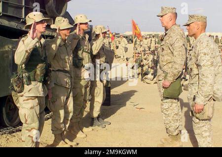 030216-M-4419R-040. [Complete] Scene Caption: Four US Marine Corps (USMC) Marines of Regimental Combat Team 5, 1ST Marine Division out of Camp Pendleton, California, stand before USMC Lieutenant General (LGEN) James T. Conway, Commanding General, 1ST Marine Expeditionary Force (MEF), Camp Pendleton, California (CA), and the regiment as they re-enlist prior to being promoted meritoriously at Camp Coyote in Northern Kuwait during Operation ENDURING FREEDOM. Standing (left to right) are: USMC Lance Corporal (LCPL) William S. Green, 2nd Battalion, 5th Marines, 1ST Marine Division, Camp Pendleton, Stock Photo