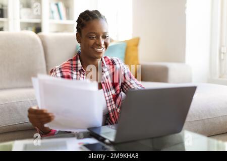 Happy pretty black lady entrepreneur working from home Stock Photo