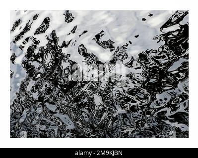Abstract photograph of black and white ripples and reflections in water ...