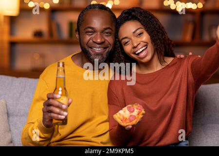 Portrait of happy black couple taking selfie at home Stock Photo