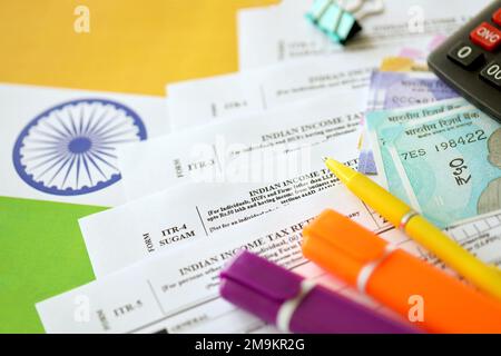 KYIV, UKRAINE - MAY 4, 2022 Indian income tax return blank form with pen and indian rupees bills on indian country flag close up. Annual tax report concept Stock Photo