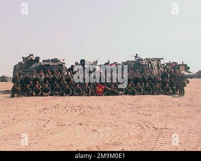 The US Marine Corps (USMC) Marines of Bravo Company (CO), 2nd Tank (TK) Battalion (BN), Marine Corps Base (MCB) Camp Lejune North Carolina (NC), stand for a photo before crossing the Iraqi border during Operation ENDURING FREEDOM. Behind them, are a AAV7A1 Amphibious Assault Vehicle (AAV) (left), M1A2 Abrams Main Battle Tank (MBT) and a M88A2 HERCULES (Heavy Equipment Recovery Combat Utility Lift and Evacuation System) vehicle. (Substandard image). Base: Camp Coyote Country: Kuwait (KWT) Stock Photo