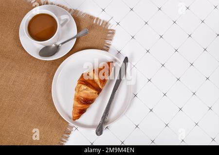 Croissant pastry on plate and cup of coffee with copy space Stock Photo