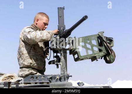 US Marine (USMC) Private First Class (PFC) William L. Carlsen, 1ST Battalion, 4th Marines, Combined Anti-Armor Team (CAAT) Bravo, cleans a Browning M2 HB 0.50 Caliber heavy machine gun on top of a High-Mobility Multipurpose Wheeled Vehicle (HMMWV) at Living Support Area 1 (LSA 1), during Operation ENDURING FREEDOM. Country: Kuwait (KWT) Stock Photo