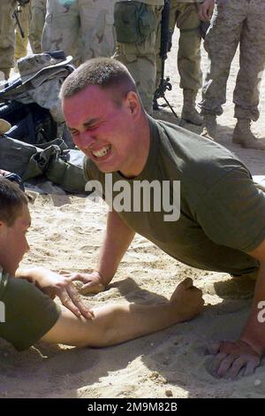 US Marine Corps (USMC) Lance Corporal (LCPL) Brad C. Distin, Charlie Company, 1ST Battalion, 5th Marines (1/5), Regimental Combat Team 5, 1ST Marine Division, Camp Pendleton, California (CA), participates in the pushup competition during the 1/5 field meet at Camp Coyote in Northern Kuwait during Operation ENDURING FREEDOM. Base: Camp Coyote Country: Kuwait (KWT) Stock Photo