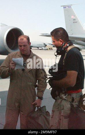 US Air Force (USAF) Captain (CAPT) James Spencer, 319th Expeditionary Air Refueling Squadron (EARS), and USAF Technical Sergeant (TSGT) John Baker, Maintenance Crewchief, go over a maintenance checklist prior to a refueling mission. The 319th EARS conducts combat and combat-support air refueling and airlift missions across US Central Commands (USCENTCOM) area of responsibility (AOR) supporting Operations ENDURING FREEDOM, SOUTHERN WATCH, and IRAQI FREEDOM. (Substandard image). Country: Unknown Stock Photo