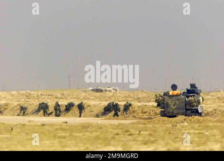 US Marine Corps (USMC) Marines assigned to Charlie Company, 1ST Battalion, 7th Marines, observe an abandoned Iraqi T-55 Main Battle Tank (MBT) near Az Zubayr, Iraq, during Operation IRAQI FREEDOM. (Substandard image). Subject Operation/Series: IRAQI FREEDOM Base: Az Zubayr Country: Iraq (IRQ) Stock Photo