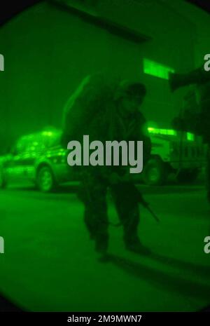 A night vision photo of a US Marine Corps (USMC) member from Fox Company, Battalion Landing Team, 2nd Battalion, 2nd Marines, 24th Marine Expeditionary Unit (MEU) moving from a hangar to the flight line. (Substandard image). Subject Operation/Series: IRAQI FREEDOM Country: Kuwait (KWT) Stock Photo