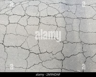 A vertical overhead shot of cracked asphalt - perfect for background Stock Photo