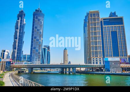 DUBAI, UAE - MARCH 6, 2020: Walk along Dubai Water Canal and watch futuristic JW Marriot Marquis and Al Habtoor City buildings behind Dubai Waterfall Stock Photo