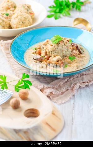 Homemade Bavarian bread dumpling, called in south Germany as Semmelknoedel with creamed mushroom sauce Stock Photo
