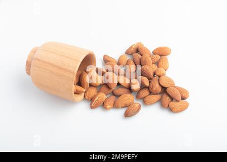 Almonds in a wooden cup on a white background Stock Photo