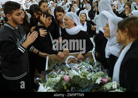 Members of the Israeli Druze minority mourn around the body of Tiran ...