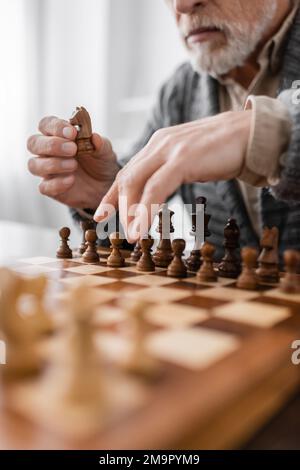 partial view of senior man with alzheimer syndrome playing chess at home,stock image Stock Photo