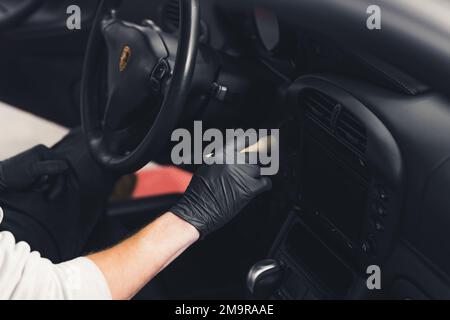 Car detailing professionalism cleaning the inside of sports car with a brush. Car dashboard cleaning. High quality photo Stock Photo