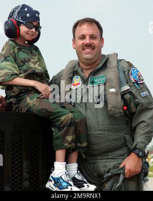 030814-F-2621S-006. [Complete] Scene Caption: Garrett Matuszewski (left) a 10-year-old guest of the Make-A-Wish Foundation, and US Air Force (USAF) Major (MAJ) Michael Digby, an F-16C Fighting Falcon aircraft Pilot, assigned to the 108th Fighter Wing (FW), Ohio National Guard (OHANG), poses for a photograph, on the flight line at Swanton, Ohio. Garrett's wish was to visit a military installation with F-16 fighter aircraft. Members of the 180th FW made sure to make it a memorable trip for Garrett. He spent the day on the flight line watching the jets take off while listening and talking to the Stock Photo