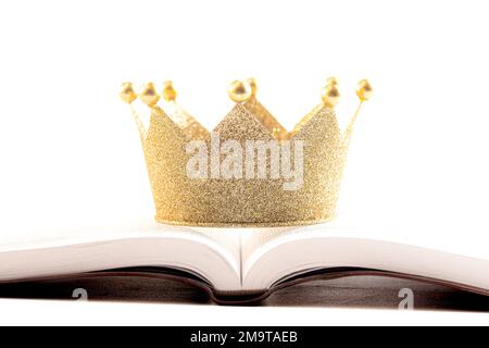 A Golden Crown on a Holy Bible Isolated on a White Background Stock Photo