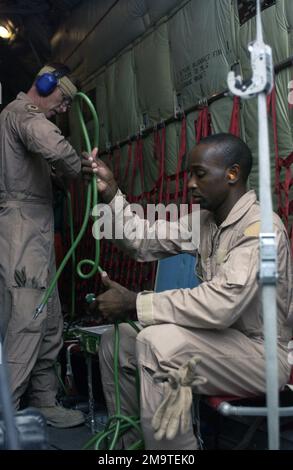 US Air Force (USAF) Technical Sergeant (TSGT) Donnie Bloomfield (front) and USAF TSGT J. D. Prosser from, 379th Expeditionary Aeromedical Evacuation Squadron (EAES), set up their equipment in the back of an USAF C-130 Hercules at Al Udeid Air Base (AB), prior to a mission supporting Operation IRAQI FREEDOM. Base: Al Udeid Air Base, Doha Country: Qatar (QAT) Stock Photo