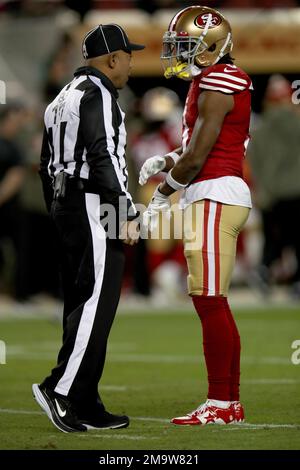 Back judge Terrence Miles (111) walks across the field during an