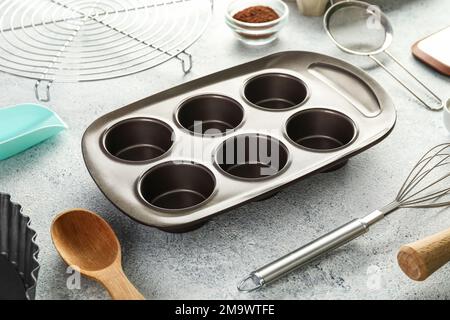 Set of utensils for baking with muffin tray on light background Stock Photo