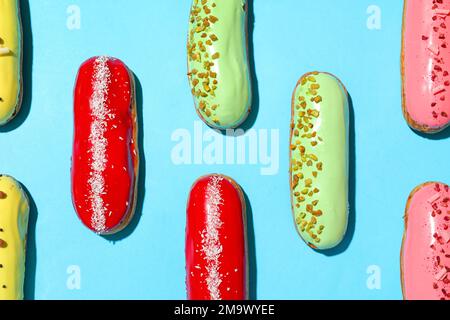 Composition with delicious eclairs on blue background Stock Photo