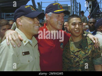 050220-N-5067K-056. [Complete] Scene Caption: Former US President William J. Clinton poses with US Navy (USN) CHIEF Operations SPECIALIST (OSC) David C. McAlister (left), and US Marine Corps (USMC) Lance Corporal (LCPL) Angelo D. Jimenez aboard the USN Whidbey Island Class Amphibious Dock Landing Ship USS FORT MCHENRY (LSD 43). USN Sailors and USMC Marines greeted former US Presidents William J. Clinton and George H. W. Bush as they toured various spaces aboard the ship receiving operational briefings on each sections participation in humanitarian relief efforts at Banda Aceh on the island of Stock Photo