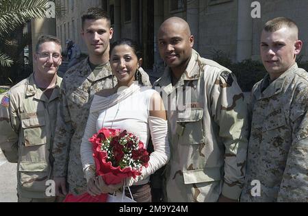 Marines, Sailors, and Soldiers deployed to Iraq in support of Operation IRAQ FREEDOM, pose for a photograph with Miss New York,├ Jaclyn Nesheiwat, in front of the Coalition Provisional Authority Headquarters in Baghdad, Iraq. Pictured background left-to-right: US Navy (USN) PETTY Officer First Class (PO1) Crismon; US Marine Corps (USMC) Lance Corporal (LCPL) Griger; US Army (USA) Sergeant (SGT) Domingez, and USMC LCPL Henry. Base: Baghdad International Airport Country: Iraq (IRQ) Stock Photo