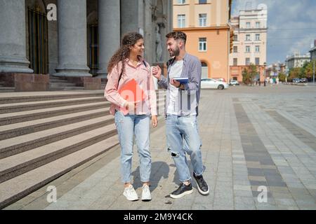 happy students leaving the university building. youth and education. Stock Photo