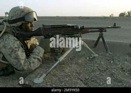 A US Marine Corps (USMC) Marine assigned to Weapons Platoon, Company E, 2nd Battalion, 1ST Marine Regiment, mans a 7.62mm M240G machine gun from a defensive position at the cloverleaf outside Highway One, near the city of Fallujah, Iraq. The Marines cut off traffic to the city in an operation to isolate and root out terrorists responsible for recent attacks on Coalition Forces during Operation IRAQI FREEDOM. Subject Operation/Series: IRAQI FREEDOM Base: Fallujah State: Al Anbar Country: Iraq (IRQ) Stock Photo