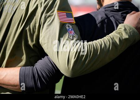 A patch for the NFL's Salute to service is seen on a sleeve of a fan during  warmup before an NFL football game between the Cincinnati Bengals and the  Carolina Panthers, Sunday