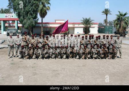 040605-M-5555L-107. [Complete] Scene Caption: US Army (USA) Drill Instructors assigned to Headquarters & Headquarters Company (H&HC), 1ST Brigade, 1ST Infantry Division, pose of a group photograph with Iraqi Civil Defense Corps (ICDC) Commandos, armed with 5.56 mm Tabuk assault rifles, at the completion of a training course conducted near Camp Hurricane Point, located on the outskirts of Ar Ramadi, Iraq. USA Soldier attached to the US Marine Corps (USMC) 1ST Marine Division (MARDIV), are engaged in Training ICDC Soldiers while conducting Security and Stabilization Operations (SASO) in the Al A Stock Photo