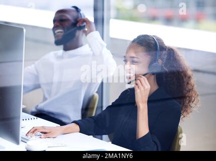 Call center, funny and employees laughing on a computer for consulting, telemarketing and customer support. Comic, contact us and happy customer Stock Photo