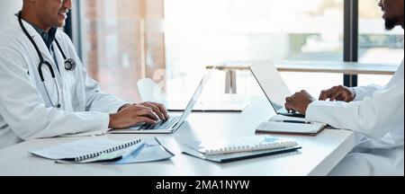 Healthcare, laptop and doctors in meeting room planning surgery schedule at table in hospital boardroom. Teamwork, clinic and innovation in medical Stock Photo