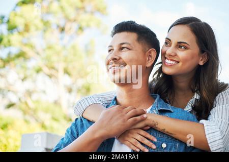 Thinking about their future. an affectionate young couple looking thoughtful while chilling outside on their patio in the yard. Stock Photo