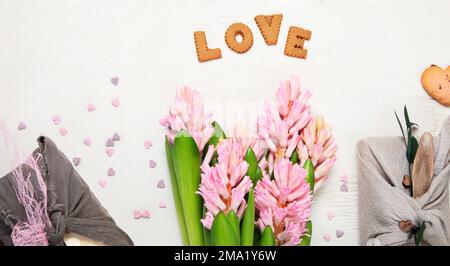 Zero waste Valentine's Day concept. Eco-friendly gift cloth wrapping in Furoshiki style, homemade sweets and cookies as gift ideas, spring flowers. To Stock Photo