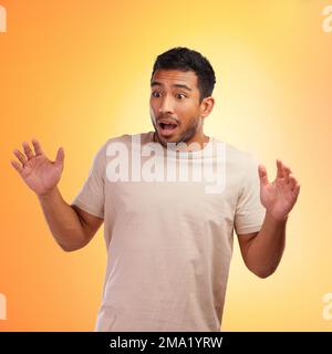 Man, surprised and standing isolated on a yellow background in shock for surprise. Shocked young male looking amazed, wow or OMG expression for deal Stock Photo