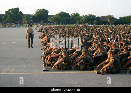 A US Marine Corps (USMC) male Drill Instructor (DI) inspects the discipline of the recruits who are seated and lined up in platoon order during the annual Independence Day celebration at Marine Corps Recruit Depot (MCRD) Parris Island, South Carolina (SC). Base: USMC Recruit Depot,Parris Island State: South Carolina (SC) Country: United States Of America (USA) Stock Photo