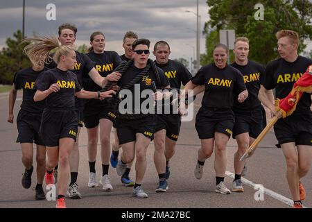 Soldiers assigned to 2nd Battalion, 77th Field Artillery Regiment, 2nd Stryker Brigade Combat Team, 4th Infantry Division run and hold on the rope to finish, May 23, 2022, during the Ivy Week 2 Mile-Run Competition at Fort Carson, Colorado. Soldiers had to hold on to the rope with their teammates throughout the the two mile-run competition. Stock Photo