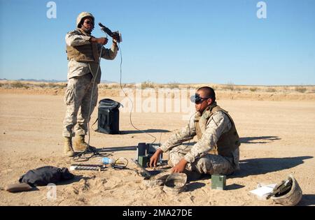 040712-M-9362G-001. [Complete] Scene Caption: US Marine Corps (USMC) Marine Lance Corporal (LCPL) Robert Diaz (sitting), from the 3rd Light Armored Reconnaissance Battalion (LARB), checks the settings on a Dragon Eye Unmanned Aerial Vehicle (UAV) while USMC Private First Class (PFC) Germond Patton winds up the bungee cord use to launch the Dragon Eye during training at the Marine Corps Air Ground Combat Center (MCAGCC), Marine Air Ground Task Force Training Center (MAGTFTC), Twentynine Palms, California (CA). The Dragon Eye is a five-lbs., back-packable, modular unmanned aerial vehicle guided Stock Photo