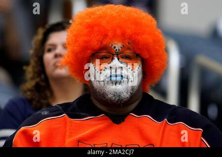 A fan wears a Dallas Cowboy cheerleader costume and pink gloves in